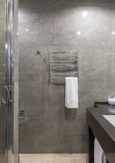 Modernes Badezimmer mit Dusche, Waschtisch und Handtuchheizkörper